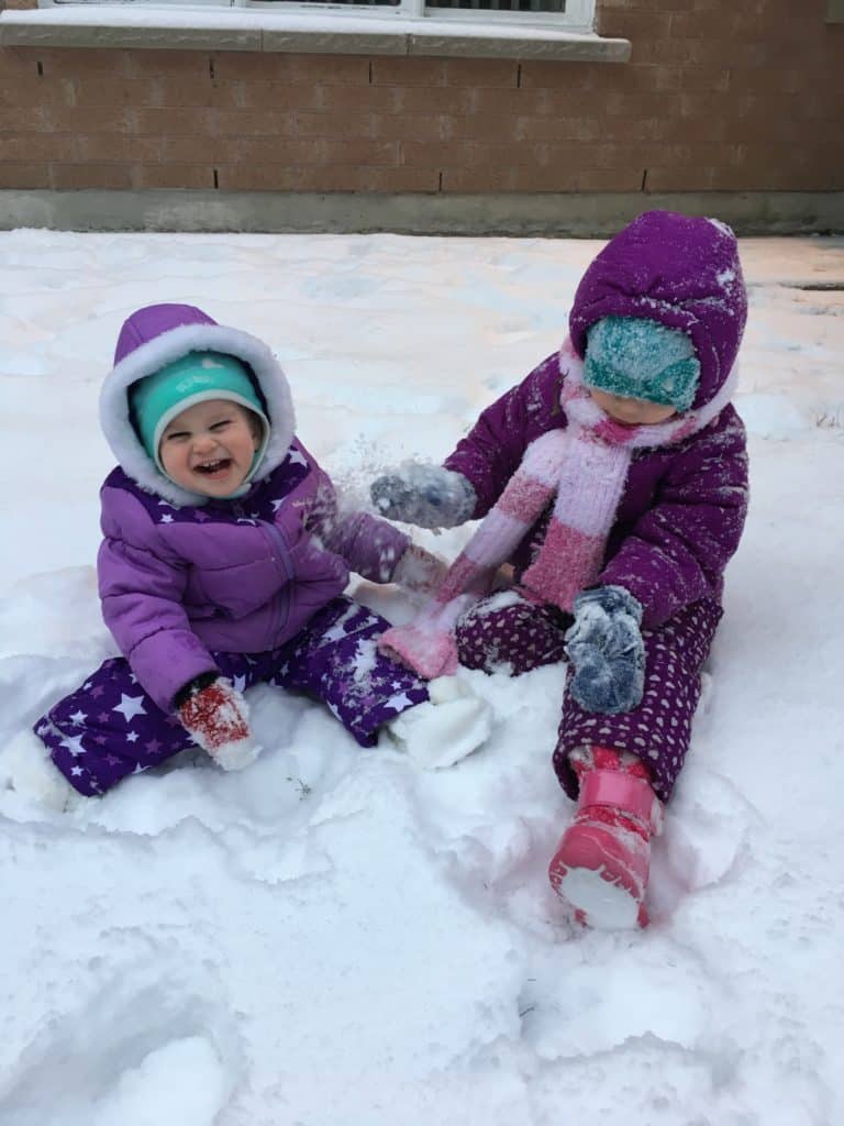 kids sitting in fresh snow